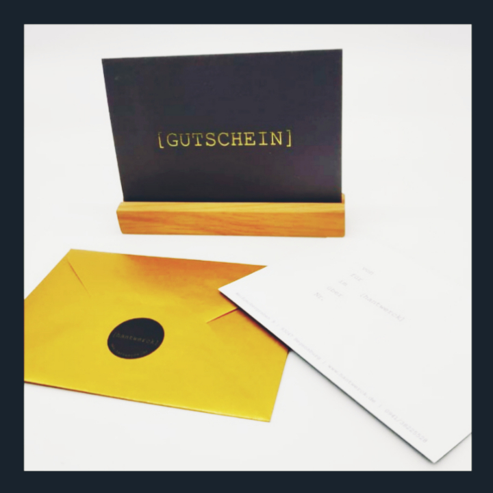 Gutschein in großem goldenem Umschlag und schwarzem Aufkleber